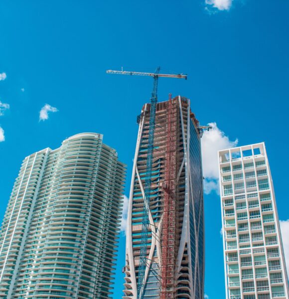 The tall buildings in a city with a blue sky in the background